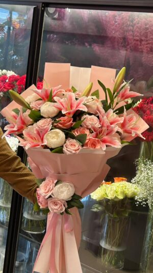 Pembe ambalajda pembe lilyum ve beyaz gül buketi